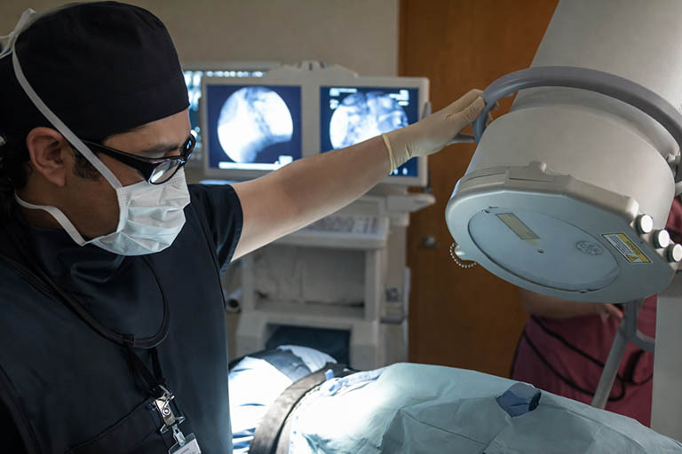 Interventional spine specialist performing image guided injection using C-arm fluoroscopy in East Brunswick NJ
