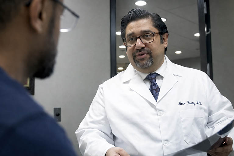 Dr Amr Hosny board certified interventional spine specialist consulting patient at pain clinic in Greenwich Village near Union Square NYC