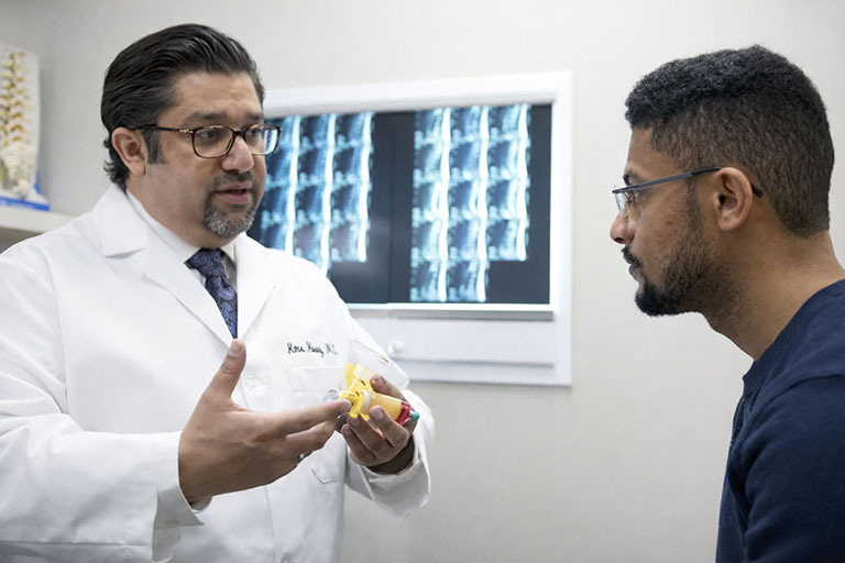 Amr Hosny MD board certified interventional pain medicine physician explaining spine condition during consultation in Paramus NJ near Route 17